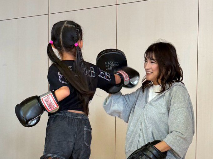 笑顔でミットを構え、子どもと向き合うRENA選手。