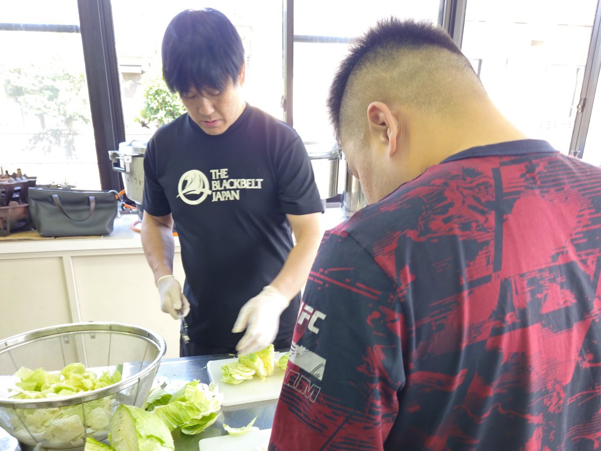 キャベツを刻む鶴屋浩氏(左)ら。