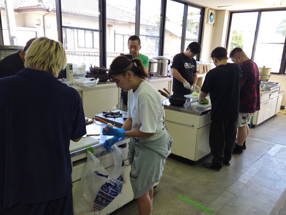 コミュニティセンターの調理室で、仕込みを進める選手たち。