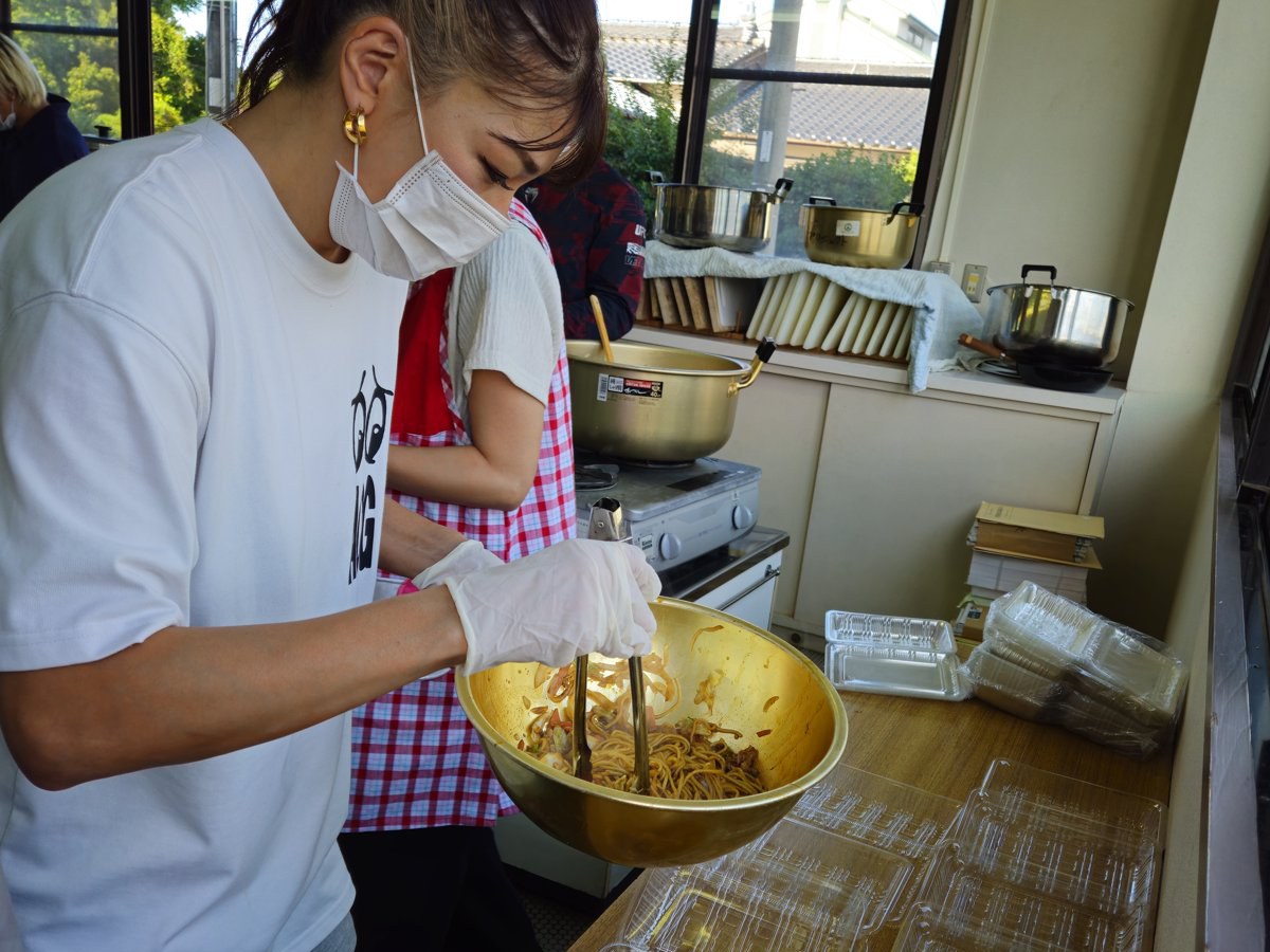 焼き上がった焼きそばをパックに詰めるRENA選手。