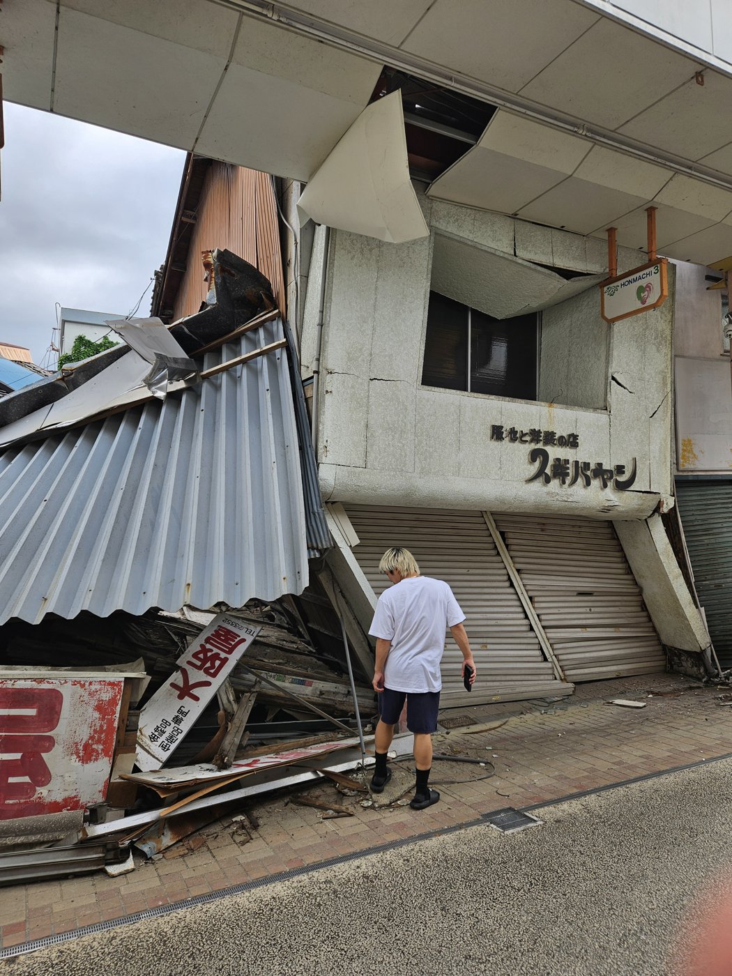 店舗の看板が崩れ落ちたままの商店街。